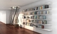 Strackk floating bookshelves under the stairs. Thin metal bookshelves for a lot of weight.