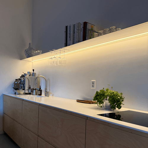 Wandplank in Raw Aluminum met verlichting onder en rondom warm licht Strackk bij klant in Ijburg Amsterdam onderaanzicht 1080 x 1080 pxl