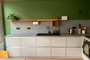 Oranje Strackk planken in keuken met keukenrolhouder en kastje