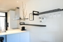 Black kitchen shelves from Strackk with wineglass rack and book supports in white kitchen