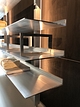 Open wandkast van Strackk In onbewerkt aluminium In perspectief en ingezoomd op planken