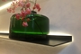Zwarte wandplank met verlichting van Strackk met groene glazen vaas Liggend
